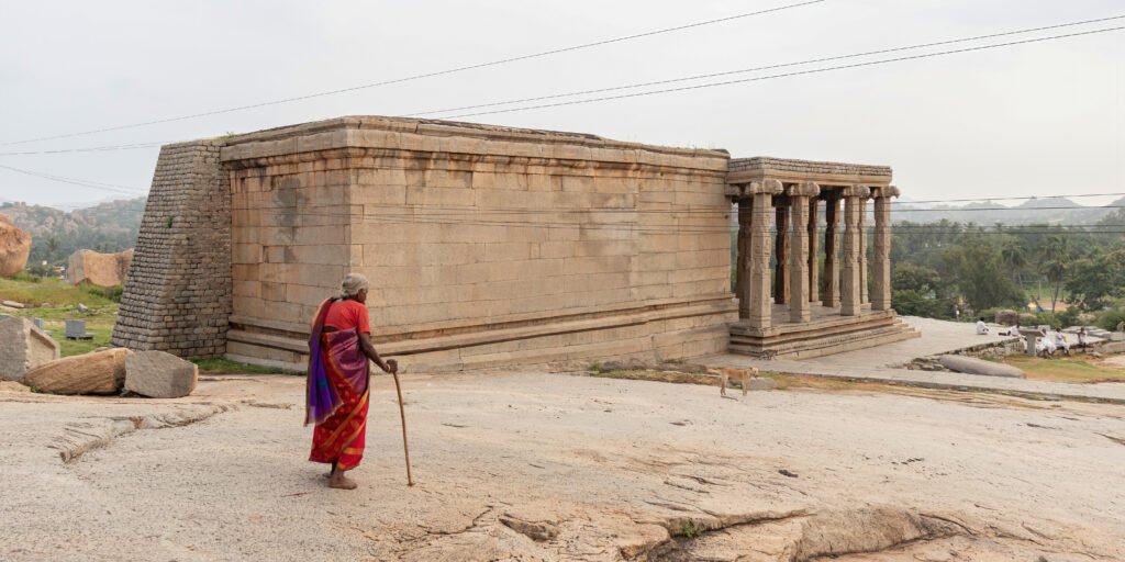 An elderly woman walking towards Kadalekalu Ganesha Temple