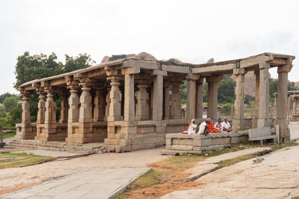 People sitting in 32 Pillar Mandapam for rest beside Kadalekalu Ganesha Temple